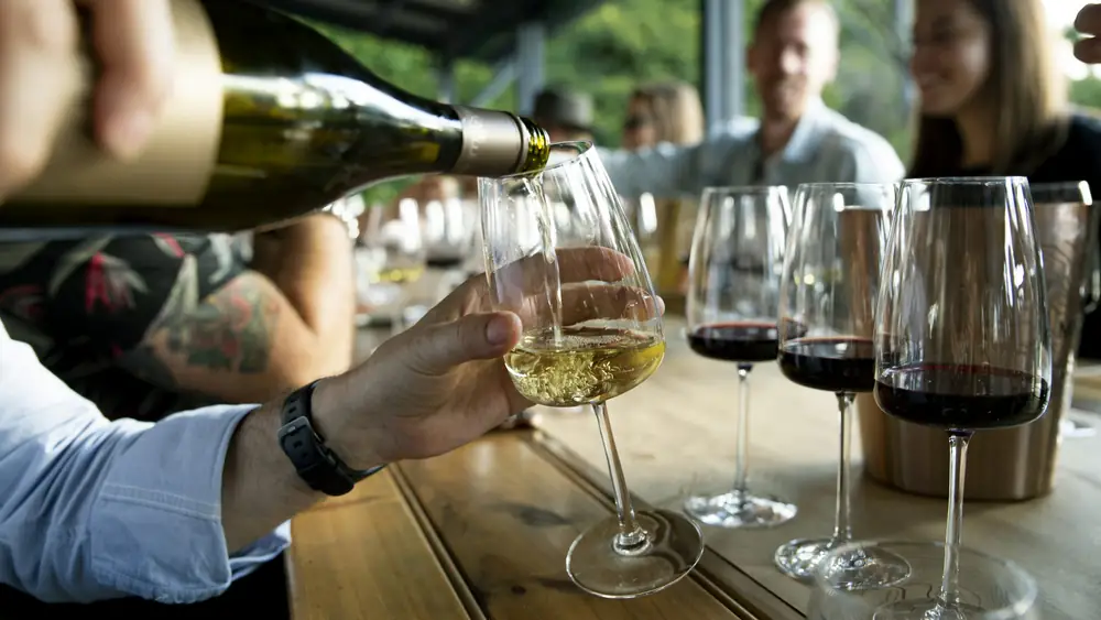 Wine being poured at a shared dining table.